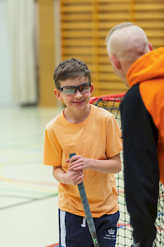 Valmentaja selin kameraan juttelemassa valmennettavan kanssa