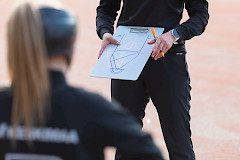 Valmentaja näyttää suunnitelmaa valmennettavilleen