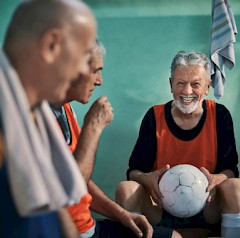 Iloisia ihmisiä, yhdellä pallo käsissä